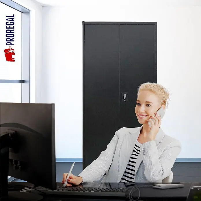 Proregal Aktenschrank ELEPHANT komplett montiert - B x T x H: 80 x 40 x 180 cm, Schwarz - Schwarzer Metallbüroschrank mit zwei Türen, in einem Büro hinter einer am Schreibtisch arbeitenden Frau.