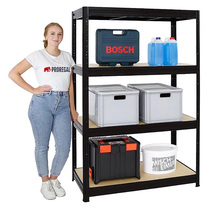 Proregal Schwerlastregal DINO - H x B x T: 180 x 120 x 60 cm, Traglast pro Boden: 600 kg, Anzahl Böden: 4 Stk., Stecken, Schwarz - Ein schwarzes Metallregal mit Holzböden, gefüllt mit Lagerartikeln. Eine Frau steht daneben und demonstriert die Größe.