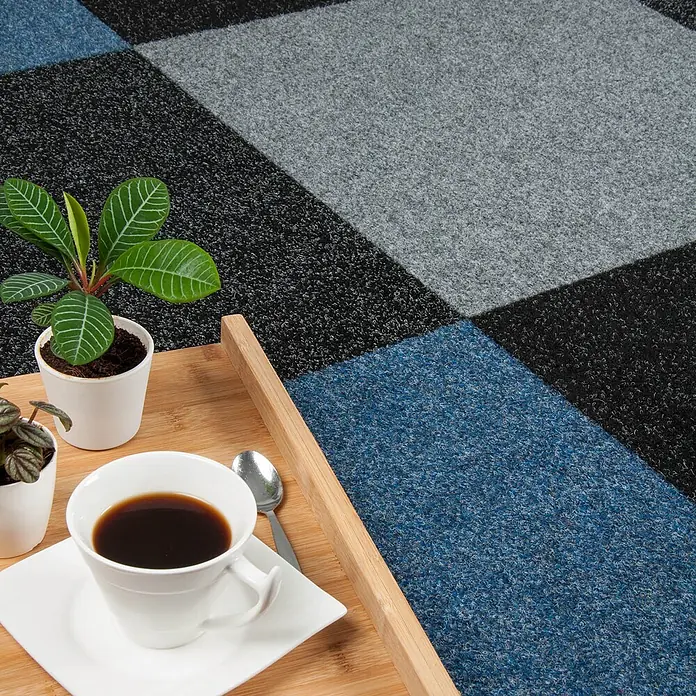 Bricoflor Teppichfliese - Breite: 50 cm, Nadelfilz, Polypropylen, grau - Modulare Teppichfliesen in blauem, schwarzem und grauem geometrischem Muster, mit Kaffee und Pflanzen auf einem Holztablett.