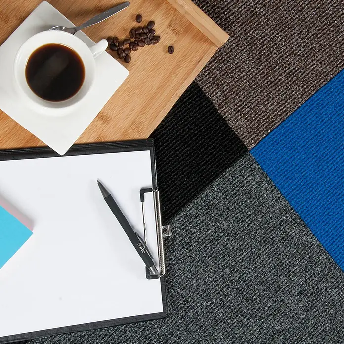 Bricoflor Teppichfliese -  - Strukturierte Bodenbelagsmuster in Braun, Schwarz, Blau und Dunkelgrau, mit Kaffeetasse und Klemmbrett.