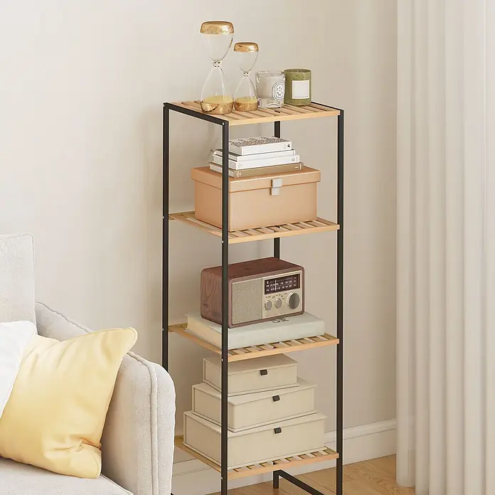 Homcom Holzregal - H x B x T: 110 x 33 x 33 cm, Traglast pro Boden: 2,5 kg, Anzahl Böden: 8 Stk., Schrauben, Naturholz - Ein hohes, schmales Regal mit schwarzem Metallrahmen und hellen Holzlattenböden, das Deko und Bücher enthält, steht neben einem Sofa in einem hellen Raum.