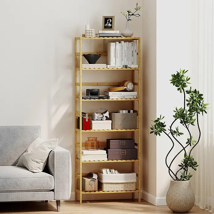 Homcom Holzregal - H x B x T: 161 x 26 x 26 cm, Traglast pro Boden: 6 kg, Anzahl Böden: 6 Stk., Naturholz - Ein hohes, schmales Regal aus natürlichem Bambus mit acht Böden, gefüllt mit Büchern und Deko, steht im Wohnzimmer.