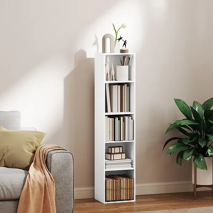 Homcom Holzregal - Traglast pro Boden: 8 kg, Anzahl Böden: 5 Stk., Schrauben, Weiß - Hohes, schmales weißes Bücherregal mit offenen Fächern, gefüllt mit Büchern und Deko, neben einem grauen Sofa.