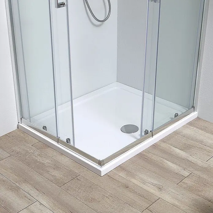 Kiamami Valentina Eckdusche - 0,02 x 0,02 x 1.900 cm, Transparent, Stärke: 6 mm - Weiße Duschwanne mit Chromablauf, umgeben von Klarglastüren und Chromrahmen auf einem holzähnlichen Boden.