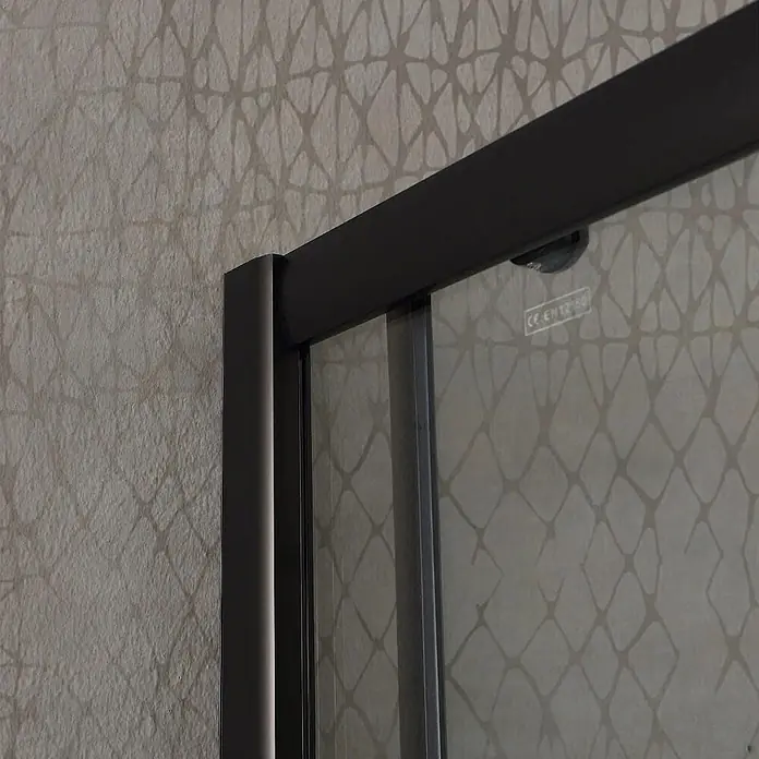Kiamami Valentina Eckdusche - 1.000 x 800 x 1.900 cm, Transparent, Stärke: 6 mm - Dunkelgrau gerahmte Glasduschabtrennung mit Oberschiene und Seitenprofil, vor einer strukturierten, gemusterten Wand.