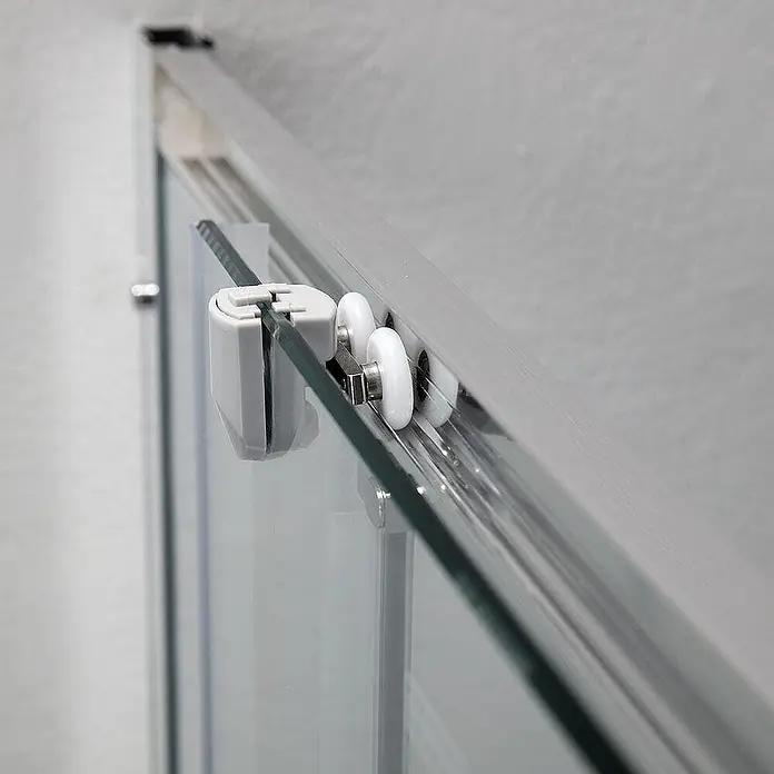 Kiamami Valentina Eckdusche - 90 x 90 x 185 cm, Transparent, Stärke: 6 mm - Nahaufnahme des oberen Schiebemechanismus einer Glasduschtür mit weißen Kunststoffrollen, Metallhalterung und grauer Führung in einer silbernen Schiene.