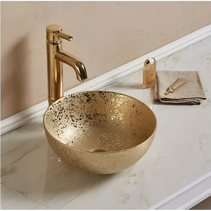 Sanicomfort Aufsatzwaschbecken Osiris - 35,8 x 35,8 cm, Hahnloch: Ohne, Ohne Überlauf, Gold - Goldene Aufsatzwaschbecken mit passendem Wasserhahn auf einer Marmorplatte.
