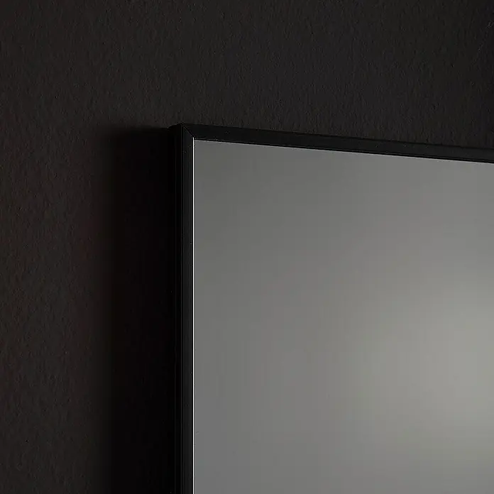 Kiamami Valentina Wandspiegel - 20 x 700 cm, Farblos - Schwarz gerahmtes graues Paneel an einer dunklen strukturierten Wand.