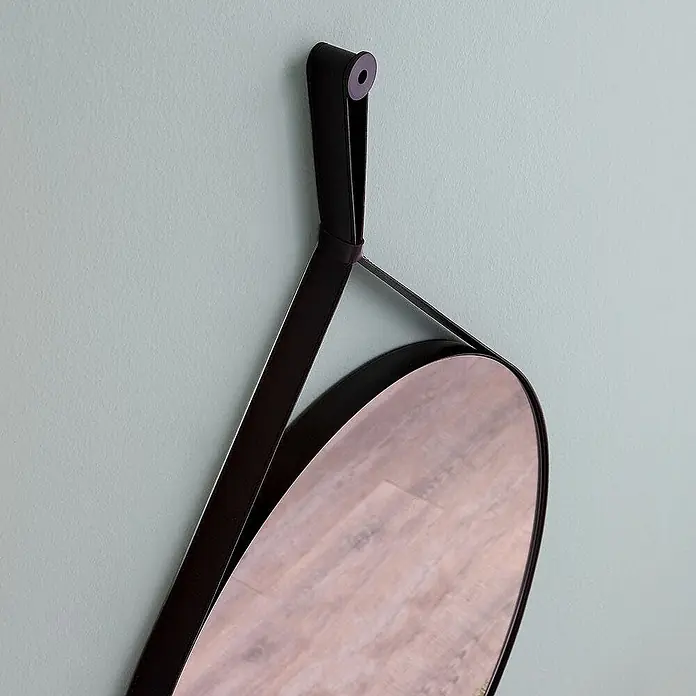 Kiamami Valentina Wandspiegel - 35 x 900 cm, Schwarz - Runder Spiegel mit schwarzem Lederriemen, an einer Wand hängend.