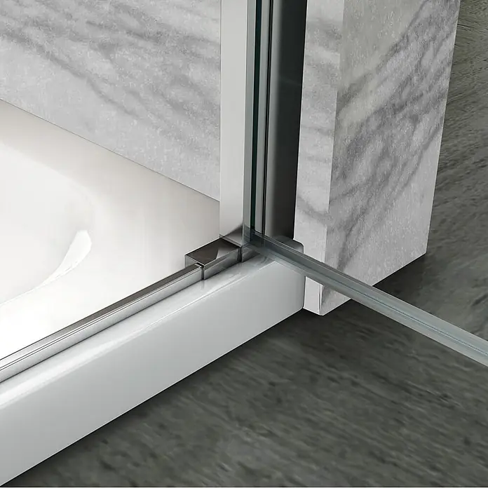 i-flair Eckdusche Matilde 80x90x180 cm - Beschichtet, Silber, Stärke: 6 mm - Nahaufnahme des unteren Rahmens und der klaren Glasscheibe einer Duschtür auf einer weißen Duschwanne.