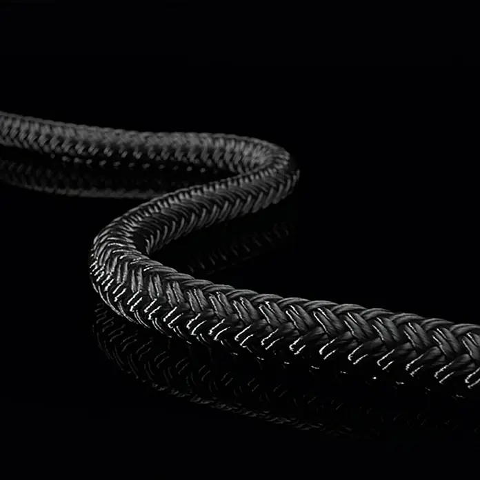 Robline Cuerda multiusos por metros Orion 500 - Diámetro: 6 mm, Poliéster, Negro - Primer plano de un cable negro resistente enrollado, reflejándose en una superficie brillante. Ideal para transferencia de datos.