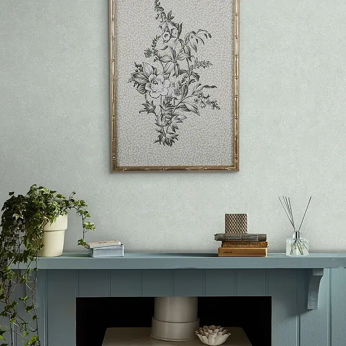 Laura Ashley Vliestapete Vliestapete Brindley - Blau, Uni, 10 x 0,52 m - Dezente mintgrüne Tapete mit marmorierter Textur, die einen Raum mit einem gerahmten Blumendruck und einem blauen Kaminsims akzentuiert.