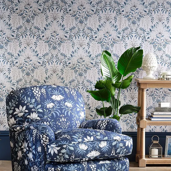 Laura Ashley Vliestapete Vliestapete Vintage Blumen - Blau/Weiß, Floral, 10 x 0,52 m - Blauer Sessel mit weißem Blumenmuster in einem Wohnzimmer, passend zur floralen Tapete.