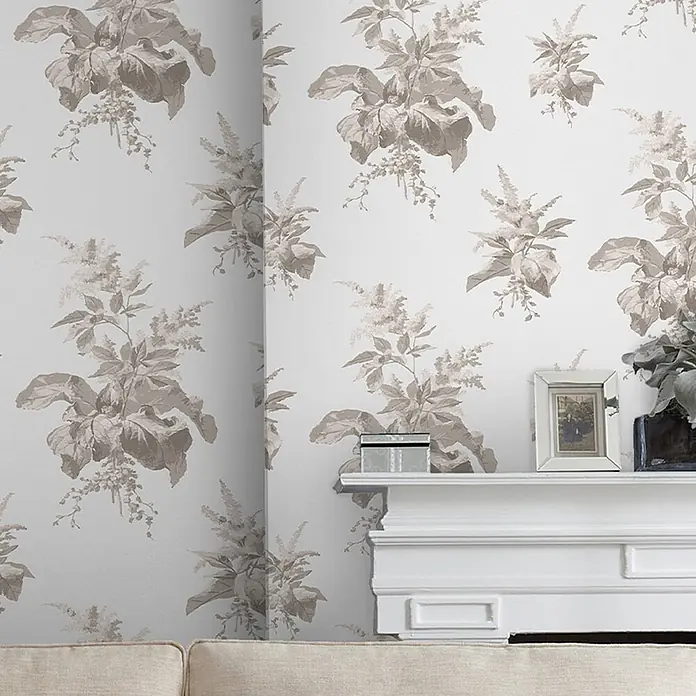 Laura Ashley Vliestapete Narberth - Grau, Floral, 1.000 x 52 cm - Tapete mit taupefarbenem Blumenmuster auf hellem Grund, schmückt eine Wand über einem weißen Kaminsims.