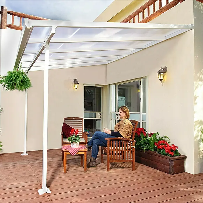 Solid Elements Terrassenüberdachung Martina - B x T: 305 x 300 cm, Verkehrsweiß, Polycarbonat, Transparent - Überdachte Terrasse mit weißem Terrassendach und sitzender Frau in entspannter Atmosphäre.