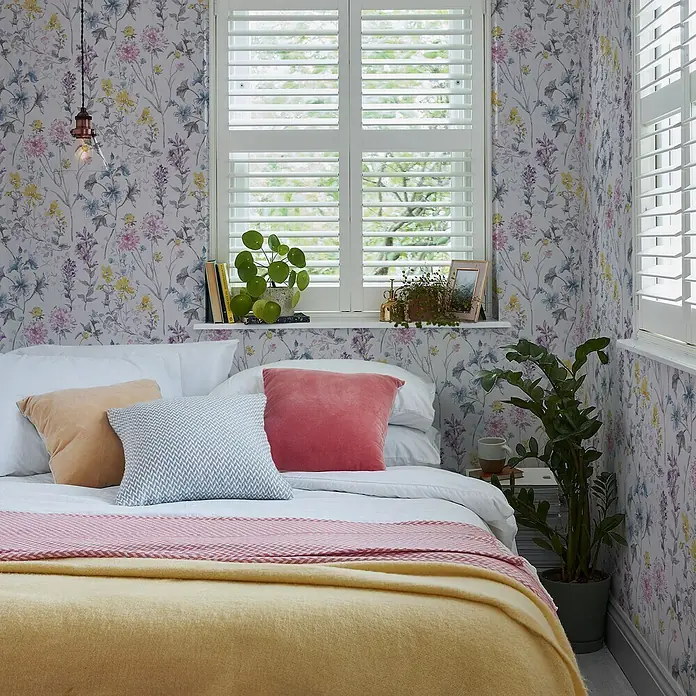 Laura Ashley Vliestapete Vliestapete Wilde Wiese - Mehrfarbig, Floral, 10 x 0,52 m - Florale Tapete mit bunten Wild- und Gartenblumen in Rosa, Gelb, Lila und Blau, angebracht in einem hellen Schlafzimmer.