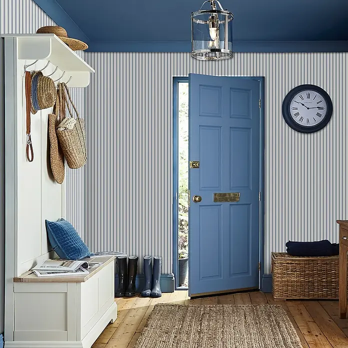 Laura Ashley Vliestapete Bauernhaus Streifen - Blau, Streifen, 1.000 x 52 cm - Weiße hölzerne Garderobenbank mit Haken und Stauraum, für Hüte und Taschen im Eingangsbereich.