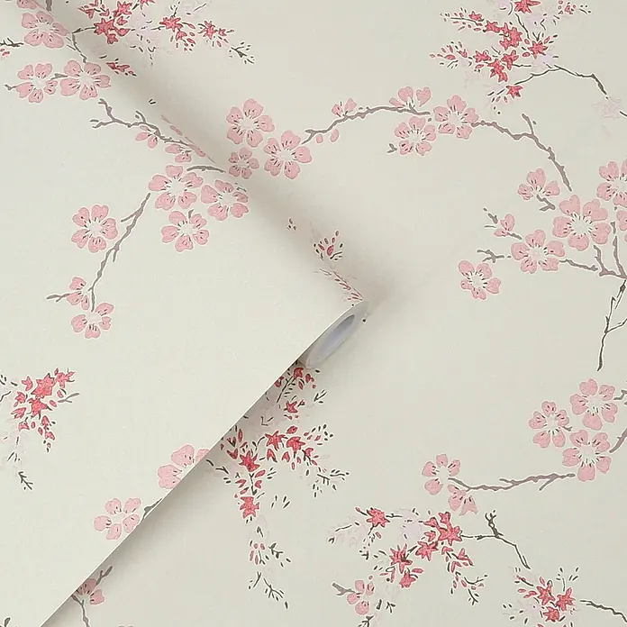 Laura Ashley Vliestapete orientalische Blüte - Rosa, Floral, 1.000 x 52 cm - Helle Tapete mit zartem Muster aus rosa und roten Kirschblüten auf Ästen, teilweise abgerollt.