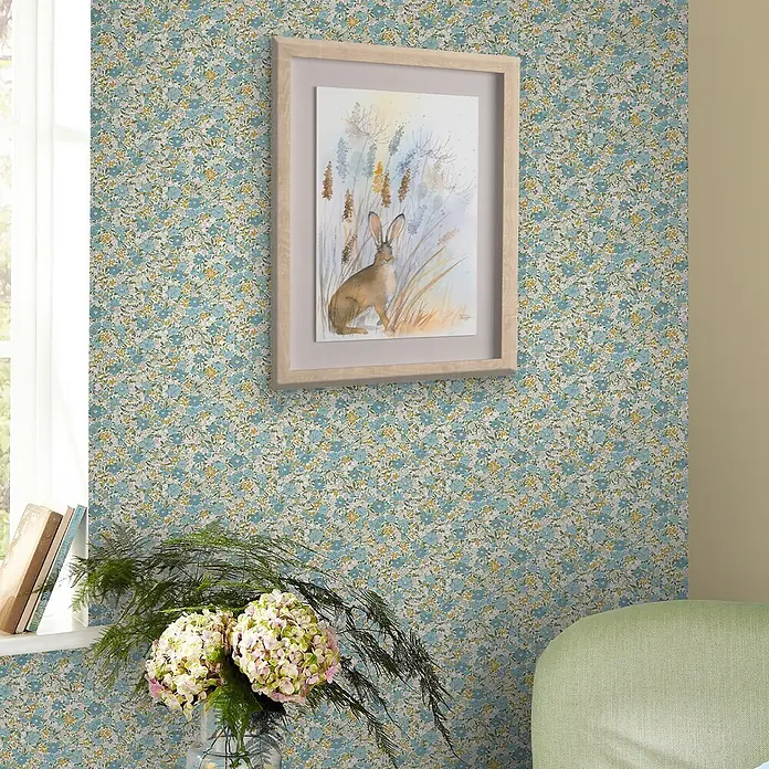 Laura Ashley Vliestapete Vliestapete Loveston Chrysanthemen - Blau, Floral, 10 x 0,52 m - Eine Wand mit blau-gelber Blumenmuster-Tapete, darauf ein gerahmtes Hasen-Aquarellbild.
