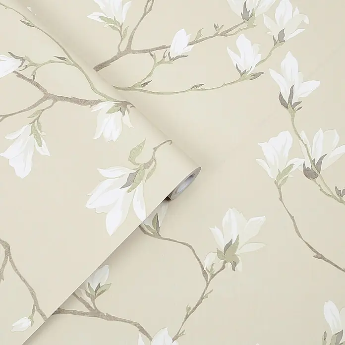 Laura Ashley Vliestapete Magnolienhain - Beige/Weiß, Floral, 1.000 x 52 cm - Eine Tapetenrolle mit beigem Hintergrund und weißen Magnolienblüten sowie braunen Ästen mit grünen Akzenten.