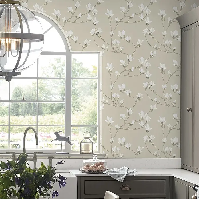 Laura Ashley Vliestapete Magnolienhain - Beige/Weiß, Floral, 1.000 x 52 cm - Beigefarbene Tapete mit weißem Magnolienmuster in einer gemütlichen Küche.