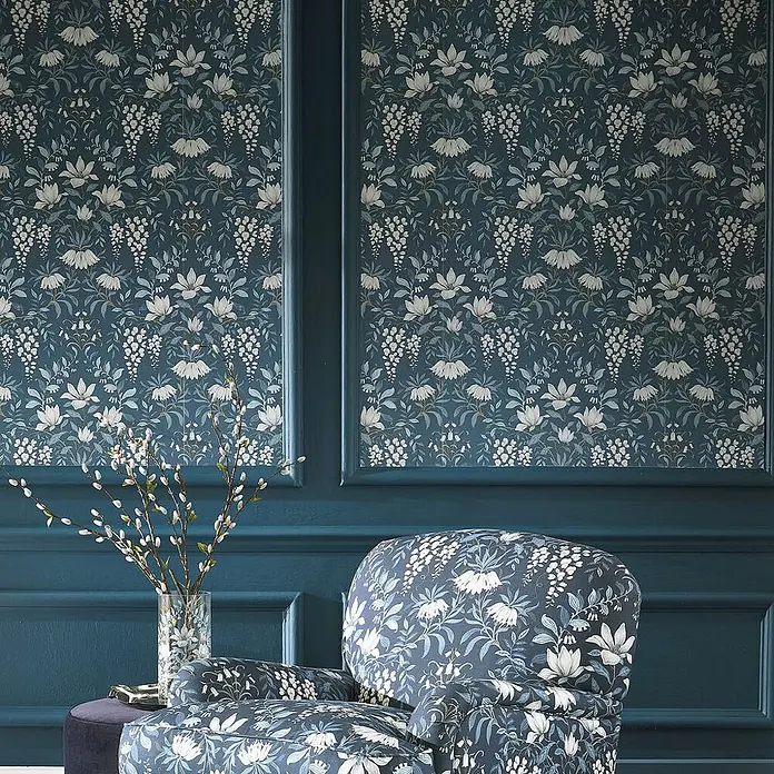 Laura Ashley Vliestapete Vintage Blumen - Blau, Floral, 1.000 x 52 cm - Dunkelblaugrüne Tapete und Sessel mit weißem Blumen- und Blattmuster, die einen Raum schmücken.