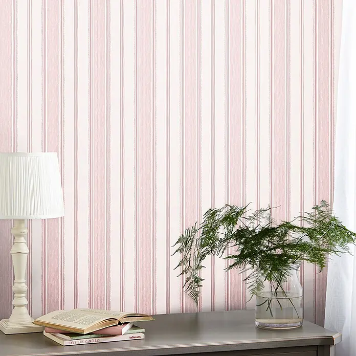 Laura Ashley Vliestapete Vliestapete Heacham - Rosa, Ornament, 10 x 0,52 m - Helle Tapete mit feinen vertikalen rot-weißen Streifen an einer Wand.