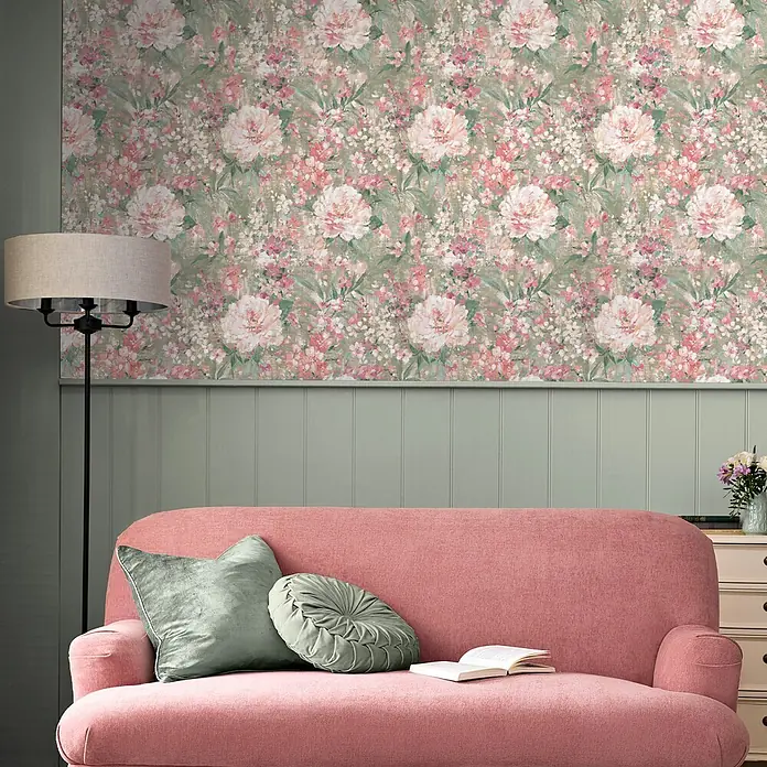 Laura Ashley Vliestapete Gemalte Blumen - Grün, Floral, 1.000 x 52 cm - Florale Tapete mit rosa-weißen Blüten auf salbeigrünem Hintergrund, schmückt eine Wand über Vertäfelung in einem gemütlichen Raum.