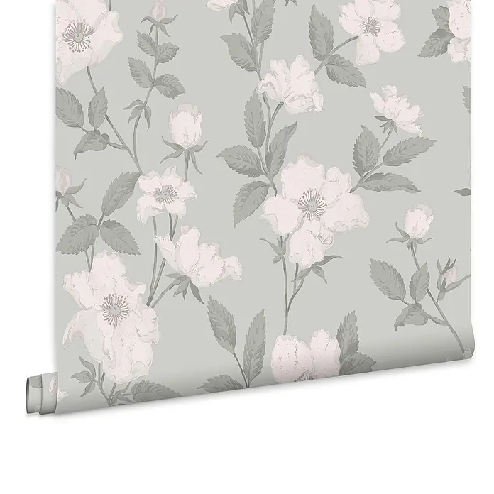 Laura Ashley Vliestapete Vliestapete Fleurir - Grün, Floral, 10 x 0,52 m - Tapetenrolle mit Blumenmuster: hellrosa-weiße Blüten und grüne Blätter auf hellgrauem Hintergrund, teilweise abgerollt.