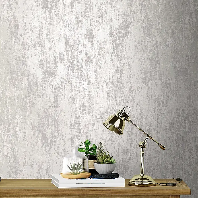 Laura Ashley Vliestapete Whinfell - Grau/Weiß, Uni, 1.000 x 52 cm - Silbergraue Tapete mit strukturierter Abnutzungsoptik, an einer Wand über einem Holzregal mit Deko.