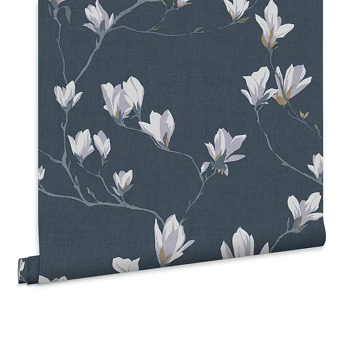 Laura Ashley Vliestapete Magnolienhain - Blau, Floral, 1.000 x 52 cm - Dunkelblaue Leinenstruktur-Tapete mit weißen und violetten Magnolienblütenmuster, teilweise abgerollt.