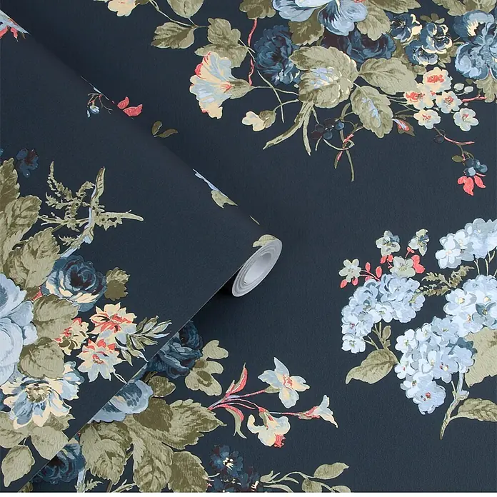 Laura Ashley Vliestapete Rosemore - Blau, Floral, 1.000 x 52 cm - Dunkle florale Tapete mit blauen, grünen und cremefarbenen Blumen auf marineblauem Hintergrund, teilweise abgerollt.