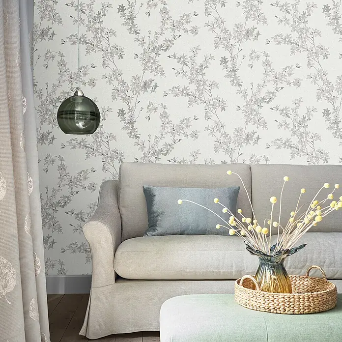Laura Ashley Vliestapete Forstyhia Blumen - Grau, Floral, 1.000 x 52 cm - Tapete mit grauem Blumenmuster auf hellem Hintergrund, in einem Wohnzimmer verwendet.