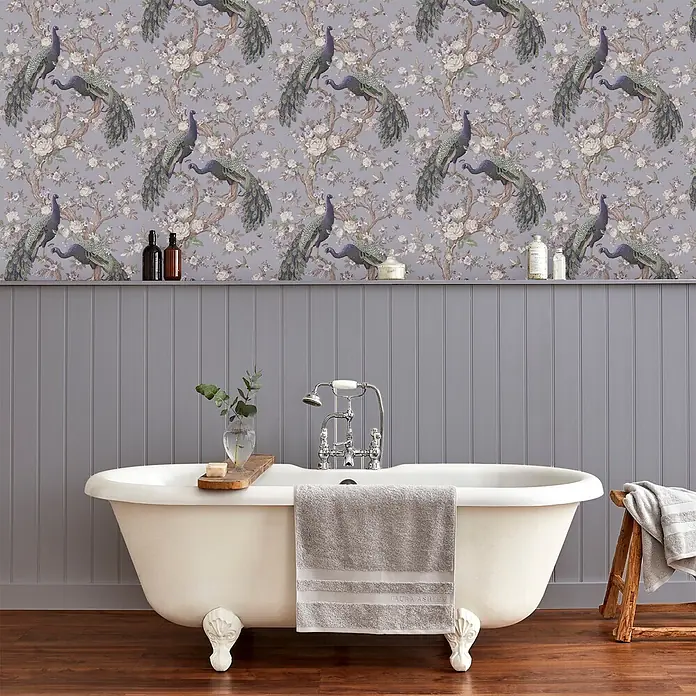 Laura Ashley Vliestapete Vliestapete Belvedere Pfau - Lila, Floral, 10 x 0,52 m - Elegante Tapete mit lila Pfauen und weißem Blumenmuster. Sie schmückt ein Badezimmer mit grauer Vertäfelung und einer klassischen Klauenfußwanne.