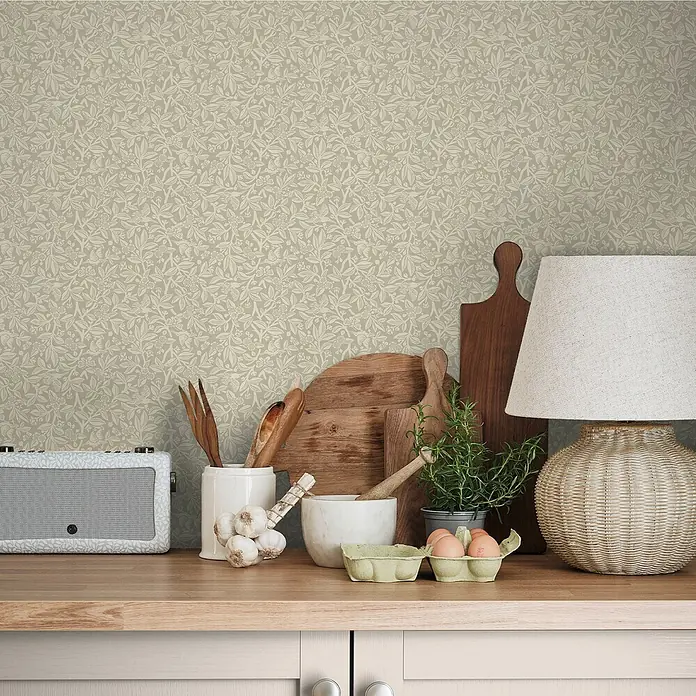 Laura Ashley Vliestapete Eichenblätter - Grau, Tieroptik, 1.000 x 52 cm - Hellbeigefarbene Tapete mit feinem botanischem Muster aus Blättern und Beeren an einer Küchenwand.