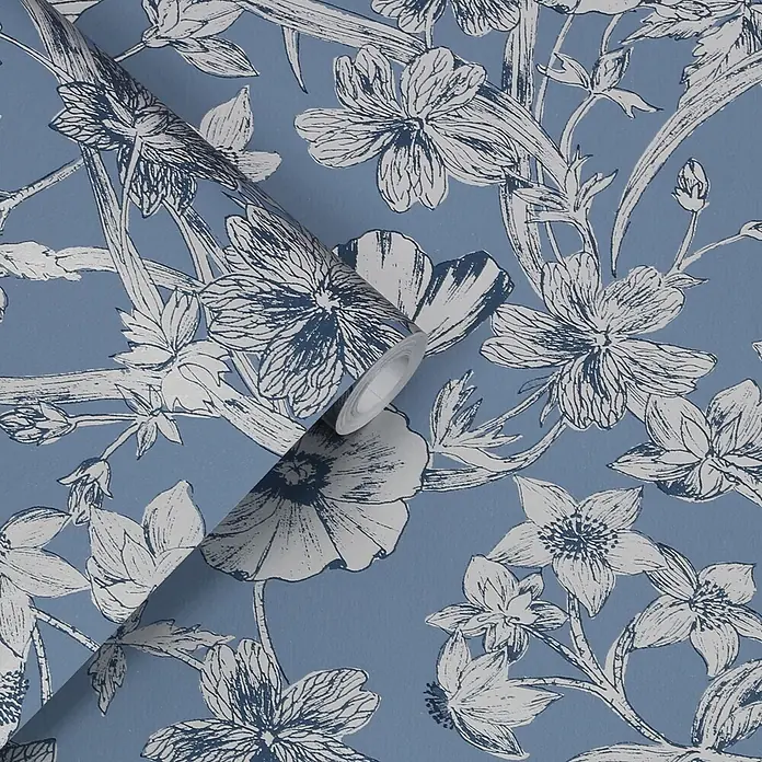 Laura Ashley Vliestapete Sommerhügel - Blau, Floral, 1.000 x 52 cm - Blaue Tapetenrolle mit weißem und dunkelblauem Blumenmuster, teilweise abgerollt zur Präsentation des Designs.