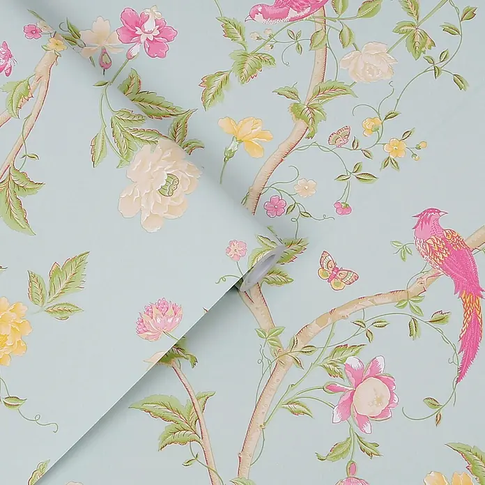 Laura Ashley Vliestapete Vliestapete Sommerpalast - Blau, Floral, 10 x 0,52 m - Hellblaue Tapete mit lebhaftem Blumen- und Vogelmuster, pinken Vögeln, gelben und pinken Blumen und Schmetterlingen, teilweise ausgerollt.