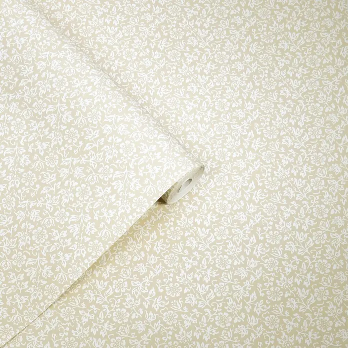 Laura Ashley Vliestapete Süßes Alyssum - Naturbelassen, Floral, 1.000 x 52 cm - Helle beige Tapete mit zartem weißem Blumenmuster, teilweise abgerollt.