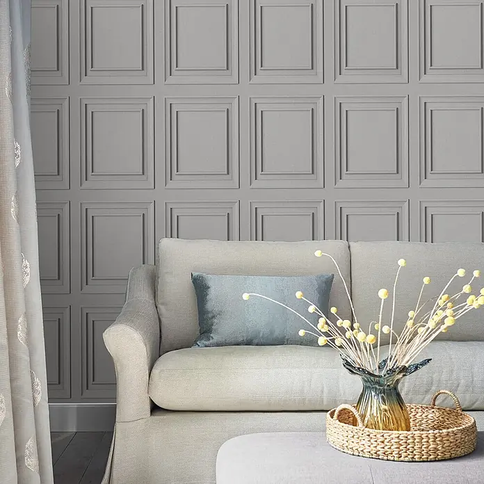 Laura Ashley Vliestapete Vliestapete Redbrook Holzplatte - Silber, Holzoptik - Graue vertäfelte Tapete, die einen eleganten Wandverkleidungseffekt in einem Wohnzimmer mit Sofa erzeugt.