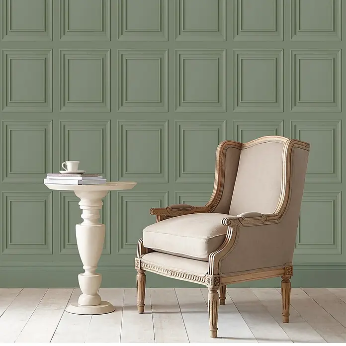 Laura Ashley Vliestapete Redbrook Holzplatte - Salbeigrün, Holzoptik, 1.000 x 52 cm - Salbeigrüne Paneelwand mit beigem Sessel und cremefarbenem Beistelltisch.