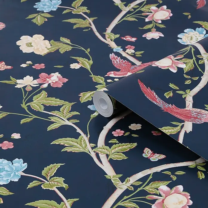 Laura Ashley Vliestapete Sommerpalast - Blau, Floral, 1.000 x 52 cm - Dunkelblaue Tapetenrolle mit Chinoiserie-Muster aus rosa, blauen und cremefarbenen Blumen, grünen Blättern und roten Vögeln auf Ästen.