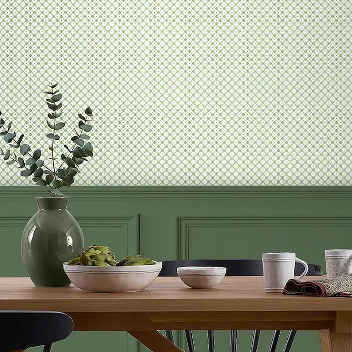 Laura Ashley Vliestapete Korbflechterei - Grün, Ornament, 1.000 x 52 cm - Hellgrüne geometrisch gemusterte Tapete über dunkelgrüner Wandverkleidung in einem Raum installiert.