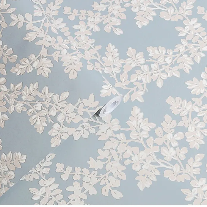 Laura Ashley Vliestapete Vliestapete Burnham - Hellblau, Floral - Hellblaue Tapete mit hellbeigem Blätterrankenmuster, teilweise abgerollt.