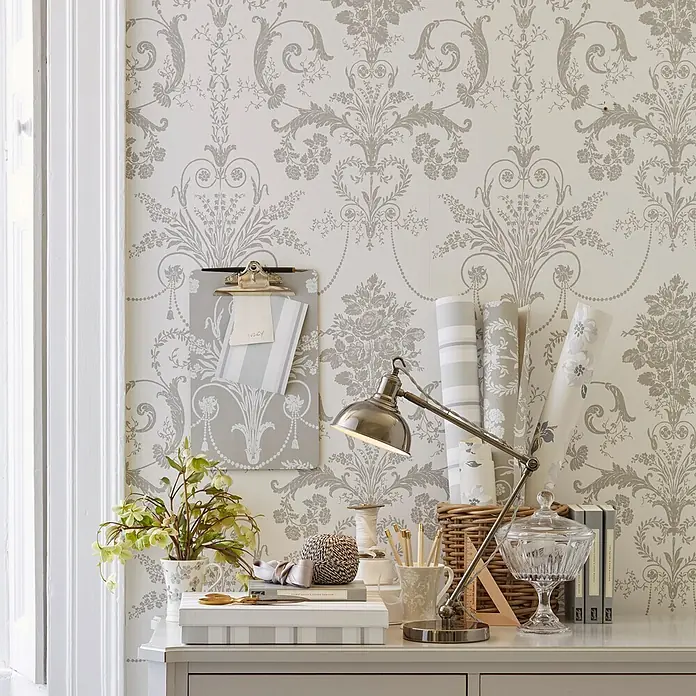 Laura Ashley Vliestapete Josette Damast - Hellgrau/Weiß, Ornament, 1.000 x 52 cm - Hellgraue Damastmuster-Tapete an einer Wand im Arbeitszimmer, mit passenden Rollen auf dem Schreibtisch.