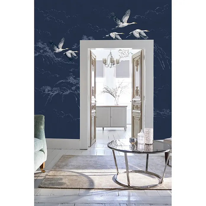 Laura Ashley Fototapete - Vlies - Dunkelblaue Tapete mit fliegenden Kranichen und dezenten Wolken- und Bergmustern.