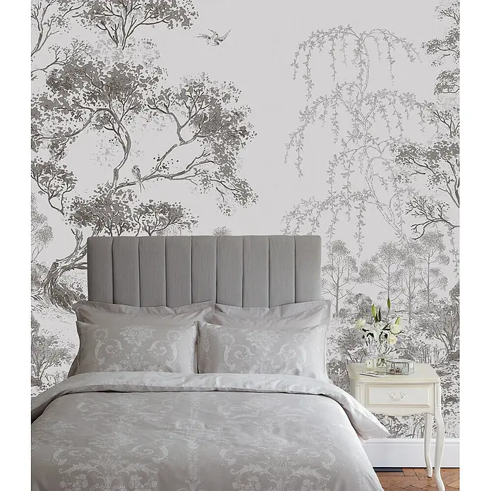 Laura Ashley Fototapete - Vlies - Eleganter grauer Bettbezug und Kissen mit Muster auf einem Bett mit passendem gepolstertem Kopfteil im Schlafzimmer.