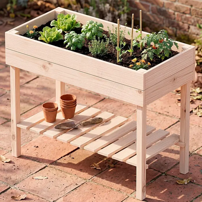 Promadino Hochbeet - 100 x 50 x 80 cm, Holz, Natur - Hochbeet aus hellem Holz mit Pflanzen und Ablage für Töpfe, auf einer Terrasse.