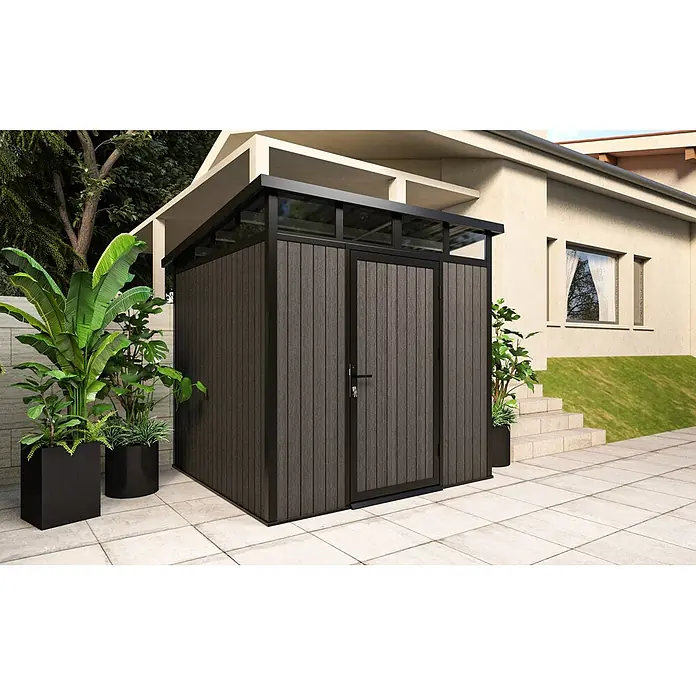 Gerätehaus 7x7 - Außenmaß inkl. Dachüberstand (B x T): 237 x 225,6 cm, Verbundwerkstoff, Silver Gray - Kompakter, dunkelgrauer Gartenhaus in Holzoptik mit schwarzem Rahmen, auf einer Terrasse neben einem Haus und Pflanzen.