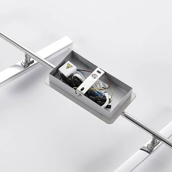 Lindby Deckenleuchte Pilou - chrom / silber - Offene Elektrobox mit Verkabelung und Hochspannungswarnsymbol, verbunden mit verchromten Leuchtenstangen.