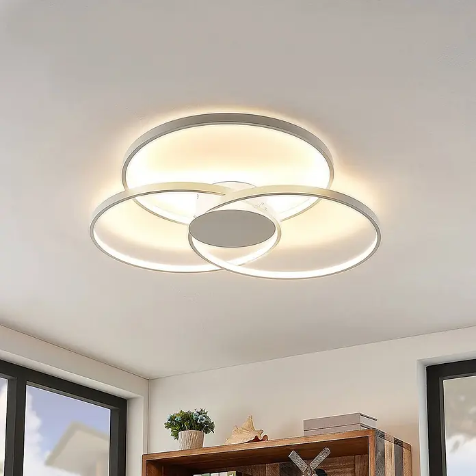 Lindby Deckenleuchte Riley - weiß / opal - Moderne weiße und silberne LED-Deckenleuchte mit überlappenden Ringen, die warmweißes Umgebungslicht spendet.